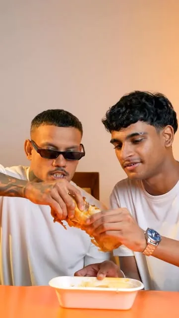 Two people sharing HOWLERS fries and dips